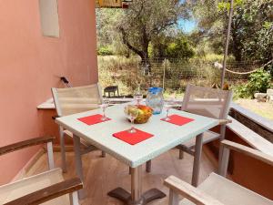 a table with two chairs and a bowl of fruit on it at Beach House in Lefkimmi
