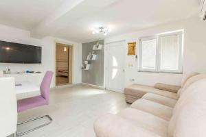 a living room with a couch and a desk at Agape Apartments in Biograd na Moru