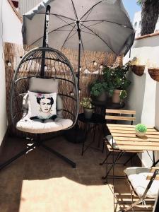 a swinging chair with an umbrella on a patio at Apartamentos Élite - Art Collection - Frida in Merida