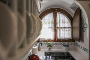 una cocina con una ventana abovedada y un fregadero en Casa Mayorazgo con Plaza de Parking en Vejer de la Frontera