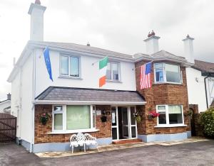 a white house with flags in front of it at AVALON HOUSE in Galway