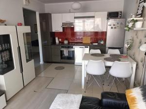 a kitchen with a white table and white chairs at Apartament Polonia in Szczecin