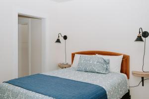 a bedroom with a bed with a blue comforter at Blue Moon Motel in Lake George