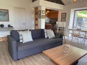 a living room with a blue couch and a table at Casa de Foros in Ribeirinha