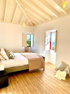 una camera con un grande letto e due finestre di Casa de Foros a Ribeirinha