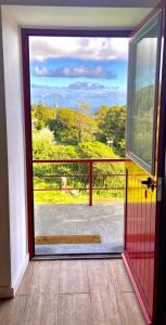 Une porte ouverte s'ouvre sur un balcon avec vue. dans l'établissement Casa de Foros, à Ribeirinha