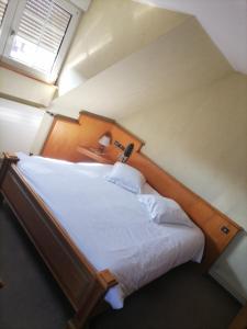 1 dormitorio con 1 cama grande con sábanas blancas en Logis Hotel Aux Comtes De Hanau en Ingwiller