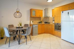 a kitchen with a table and chairs and a refrigerator at Daniel's garden apartment in Eilat