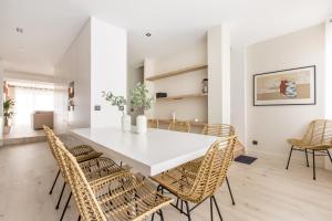 une salle à manger avec une table et des chaises blanches dans l'établissement Appartement spacieux et moderne 4 chambres à 5mn à pieds République, à Lille