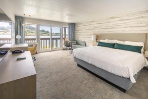 a hotel room with a large bed and a desk at Jot's Resort in Gold Beach
