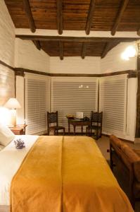 um quarto com uma cama grande e uma mesa com cadeiras em Hotel Hacienda Abraspungo em Riobamba