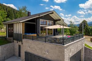 a house with an outdoor deck with an umbrella at Holiday House Abies in Ravna Gora