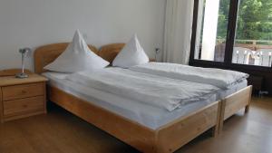 een slaapkamer met 2 bedden met witte kussens en een raam bij Arosa Brueggli B02 in Arosa