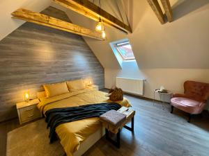 a bedroom with a large bed and a chair at Rustic Comfort House in Miercurea-Ciuc