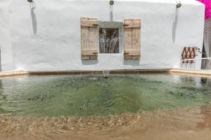 a water fountain in front of a white building at Sunrock Suites in Stelida