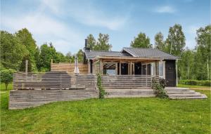 a house with a large wooden deck in the grass at Gorgeous Home In Hkerum With Lake View in Hökerum