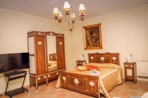 sypialnia z łóżkiem, komodą i telewizorem w obiekcie IL Tetto Di Guardia w mieście Guardia Sanframondi