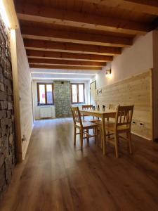 a dining room with a wooden table and chairs at Appartamento sul Ruscello in Ponte di Legno
