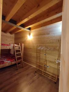 a wooden room with a bunk bed and a ladder at Appartamento sul Ruscello in Ponte di Legno