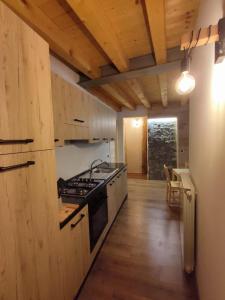 a kitchen with a stove and a table in it at Appartamento sul Ruscello in Ponte di Legno