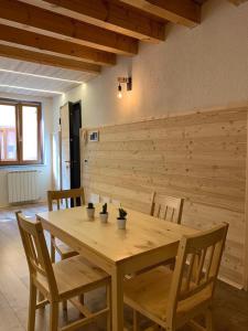 a wooden table and chairs in a room at Appartamento sul Ruscello in Ponte di Legno