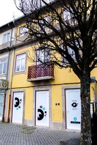 a yellow building with eyes painted on its doors at Atrium Areias in Viana do Castelo