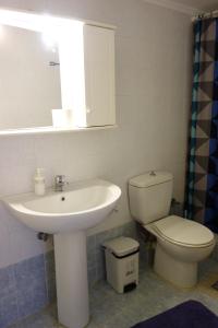 La salle de bains est pourvue d'un lavabo et de toilettes. dans l'établissement Kiki's cosy apartments, à Néa Khilí