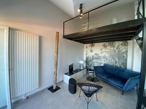 sala de estar con sofá azul y cama elevada en Appart & Fleurinoise balcon ascenseur climatisation, en Fleurieux-sur-lʼArbresle