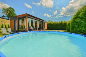 a swimming pool in front of a tiny house at Osada Kotarz in Brenna