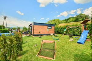 a yard with a house and a playground at Osada Kotarz in Brenna