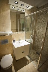 La salle de bains est pourvue de toilettes, d'un lavabo et d'une douche. dans l'établissement Apartment Red, à Belgrade