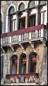 
a building with two windows and a clock on the side of it at Hotel Palazzo Vitturi in Venice
