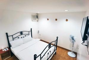 1 dormitorio con cama negra y ventilador en Marion Hotel, en Manila