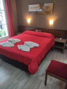 a red bed with two white towels on it at Hotel Flamingo in Mar del Plata