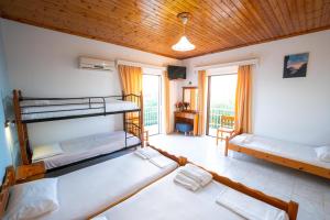 a room with three bunk beds and a balcony at Jimmy's Sea View Studios in Tragaki