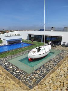 un bateau assis dans l'eau à côté d'un bâtiment dans l'établissement Monte do Carmo, à Encarnação