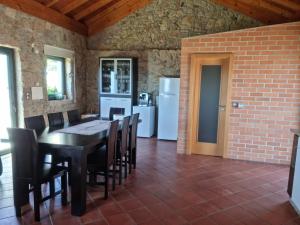 a dining room with a table and chairs and a brick wall at Florindo - Lafões Guest House in Oliveira de Frades +16 photos