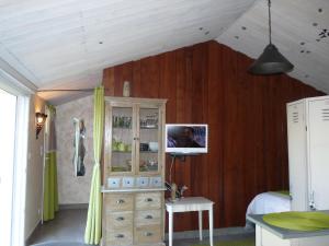 1 dormitorio con pared de madera, vestidor y cama en l'allerie studio en Les Sables-dʼOlonne