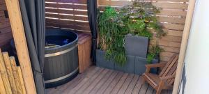 a patio with a hot tub and a wooden deck at Appart Hotel GLAM88 Suites avec SPA et Sauna Privatif in Remiremont