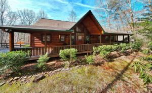 a large wooden house with a porch and a porch at Vintage Luxury Mountain Cabin, Creekside, King Bed, Spa, Fire Pit, Game Room, DogsOk in Hiawassee