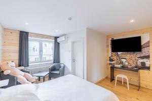 a hotel room with a bed and a flat screen tv at Esplanade Hotel in Diekirch