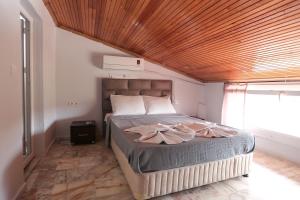 a bedroom with a large bed with a wooden ceiling at Ciftlik Hotel in Çeşme