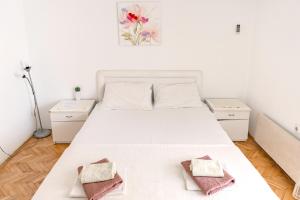 a bedroom with a white bed with two towels on it at Guest House Jasna in Budva