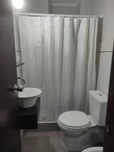 a bathroom with a white shower curtain and a toilet at Hotel Flamingo in Mar del Plata