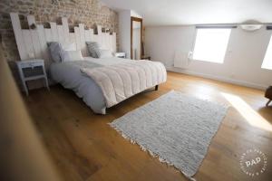 Un dormitorio con una cama grande y una alfombra blanca en la Belle Endormie, en Saint-Just