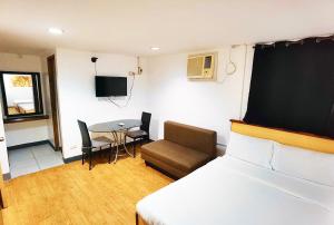 a bedroom with a bed and a table and a chair at Marion Hotel in Manila