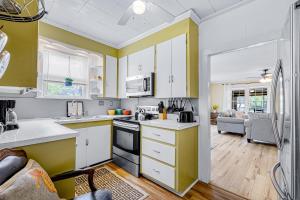 uma cozinha com armários amarelos e brancos e uma sala de estar em Folly - Beaches Be Crazy #A em Folly Beach