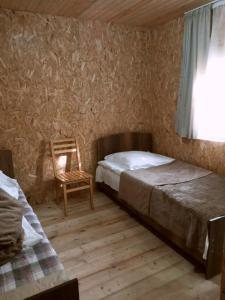 OmaloにあるGuesthouse Sagrilaのベッドルーム1室(ベッド1台、椅子、窓付)