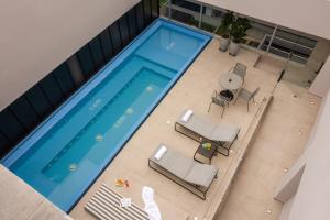 an overhead view of a swimming pool with chairs and a table at Hotel Sites Barranquilla in Barranquilla