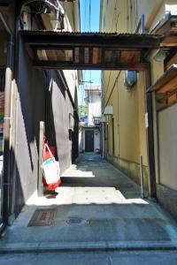 an alley way with a bag on the side of a building at 東山の宿 藤屋 in Gionmachi